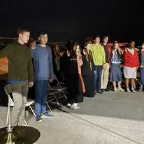 Group of people standing outside at night.