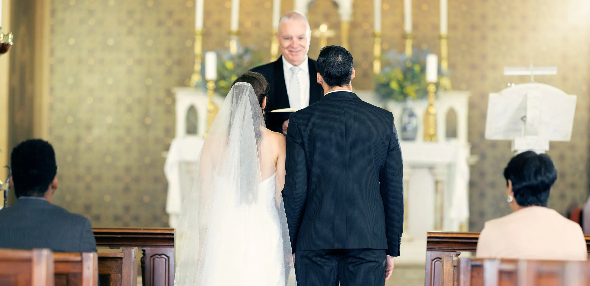 Bride and groom standing at church altar.