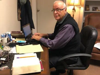Man working at desk with laptop.