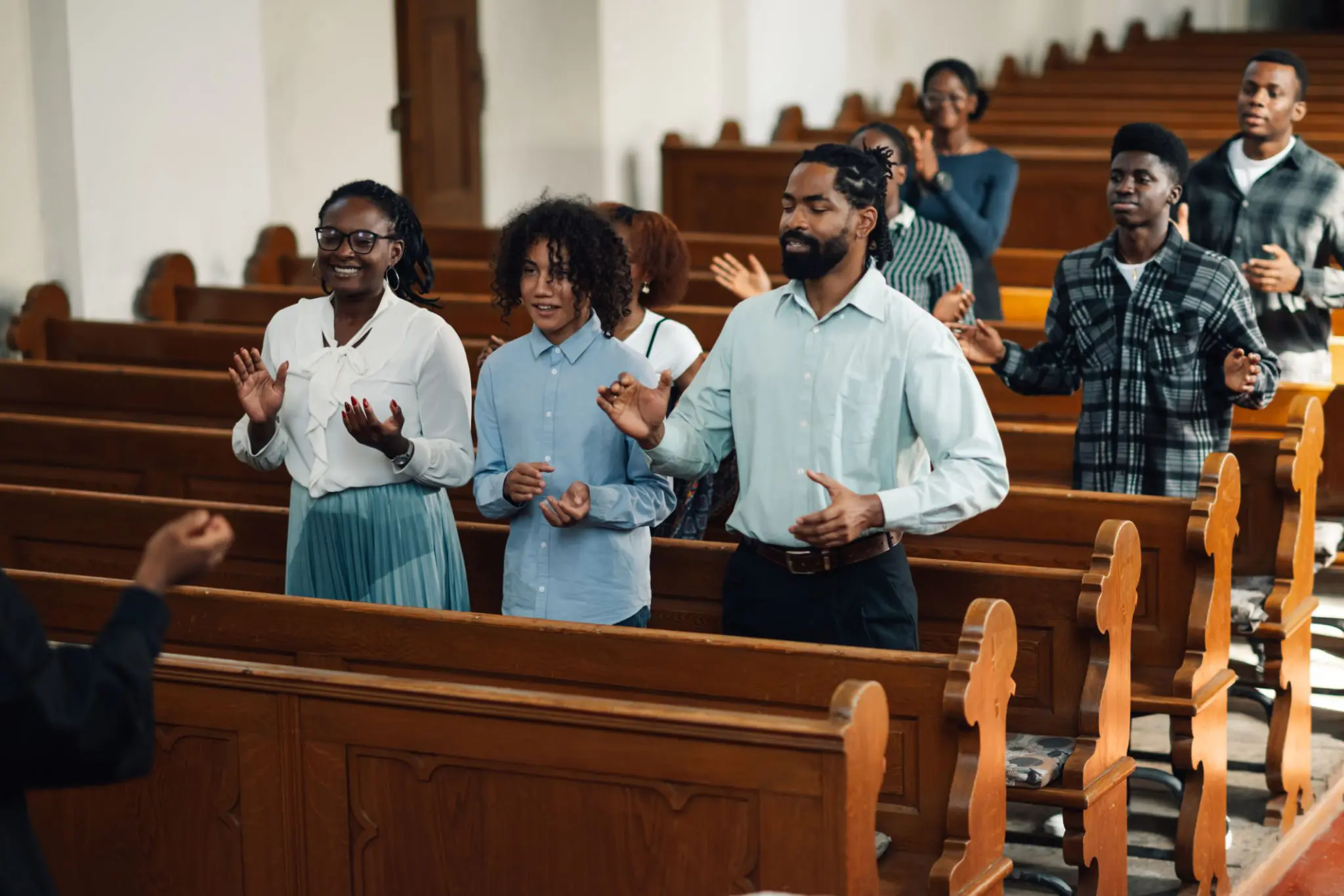 People standing and clapping in church service.