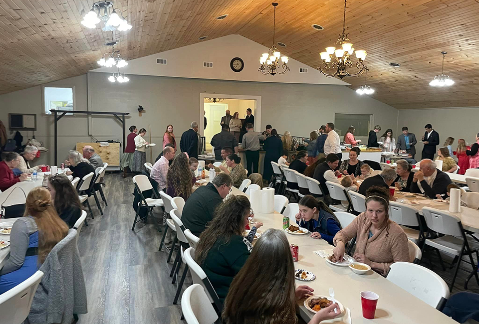 People dining in a large banquet hall.