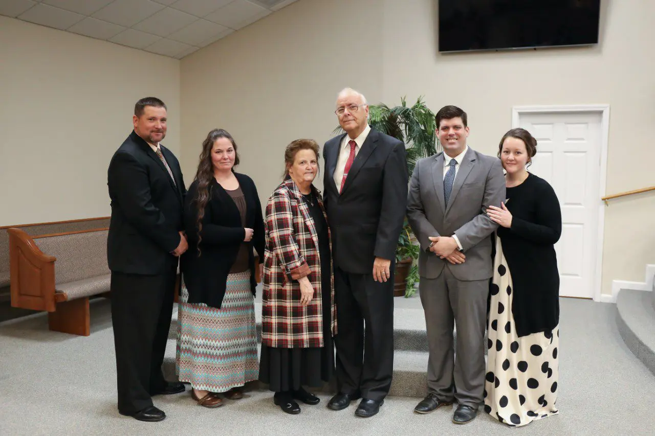 Group of people posing in formal attire.