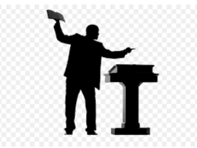 Silhouette of person speaking at podium.