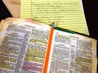 Open Bible with notes and pencil.