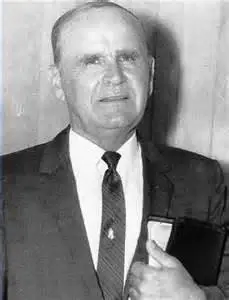 Man in suit holding a book.