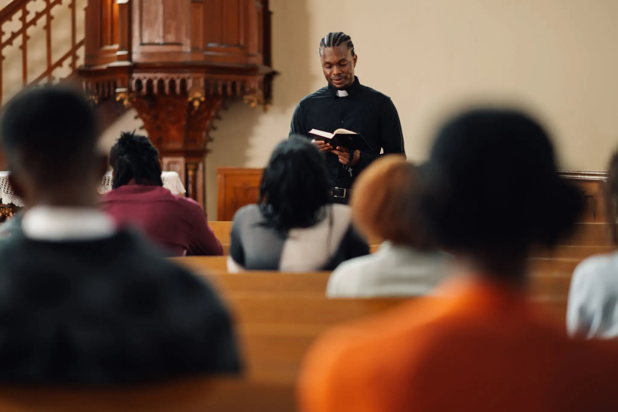 Pastor reading to congregation in church.