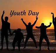 Silhouetted people celebrating Youth Day sunset.