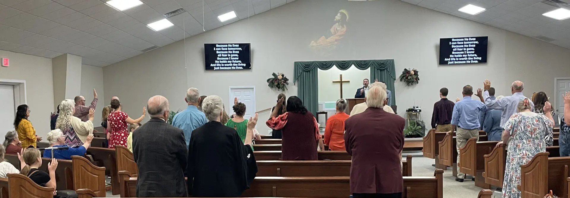 Congregation standing during church service with cross
