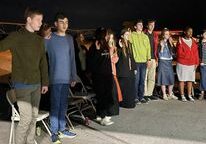 Group of people standing outside at night.