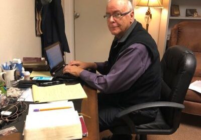 Man working at desk with laptop.