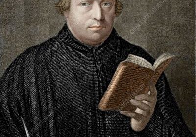 Man in robe holding a book.